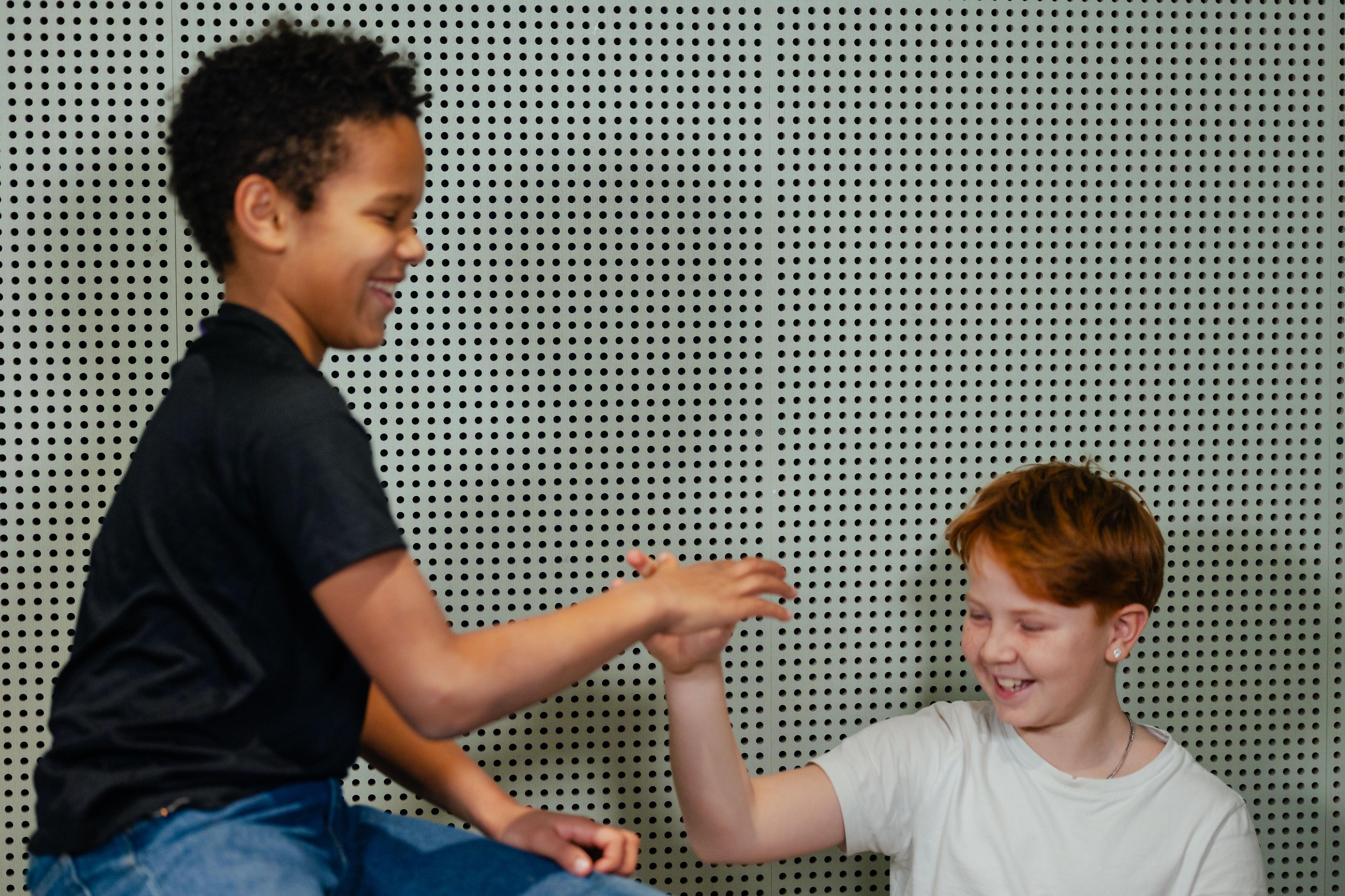 To drenge griner og fjoller med et skørt handshake